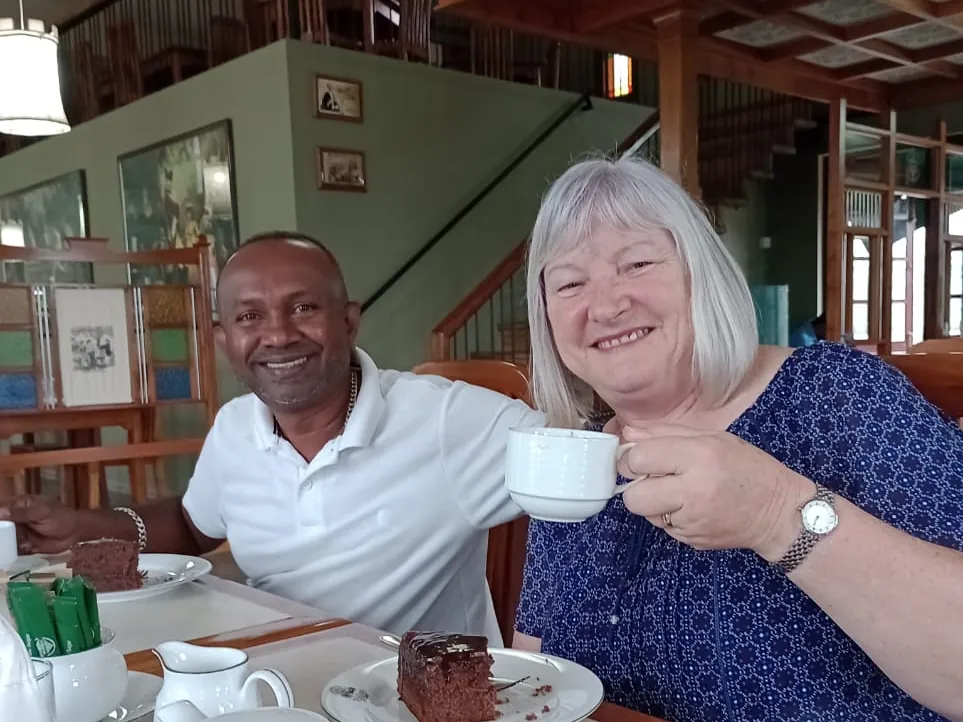 Tour guide Romesh with a female tour guest enjoying tea and cake during a tour of Sri Lanka.